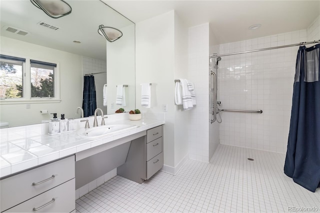 full bath with visible vents, tile patterned flooring, tiled shower, and vanity