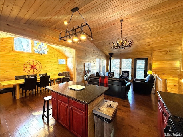 kitchen featuring wooden ceiling, dark hardwood / wood-style floors, a wood stove, a kitchen island, and an inviting chandelier