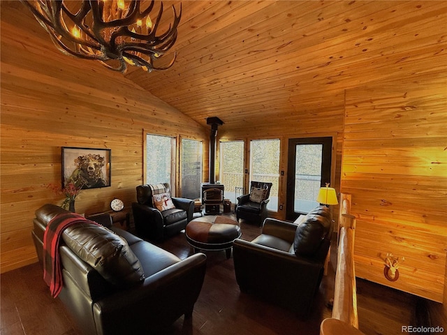 living room with hardwood / wood-style flooring, vaulted ceiling, a notable chandelier, wood ceiling, and a wood stove