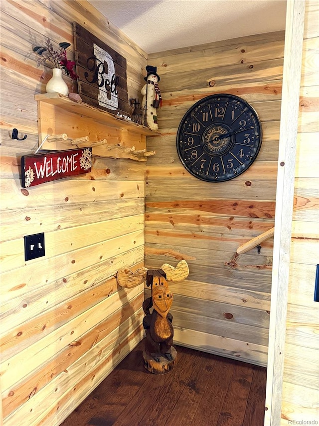 room details with a textured ceiling, wooden walls, and hardwood / wood-style flooring