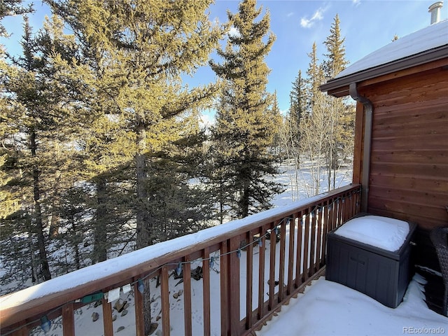 view of snow covered back of property