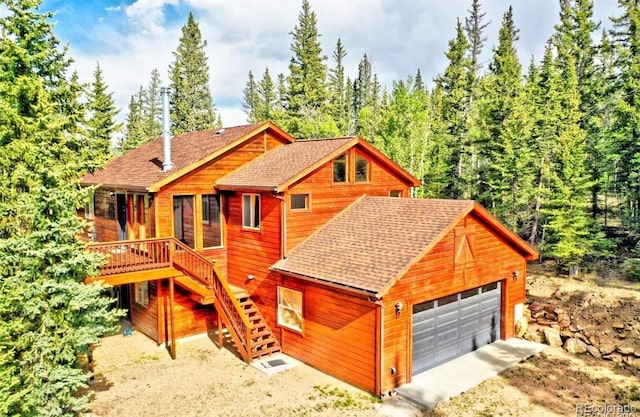 log cabin featuring a garage and a wooden deck