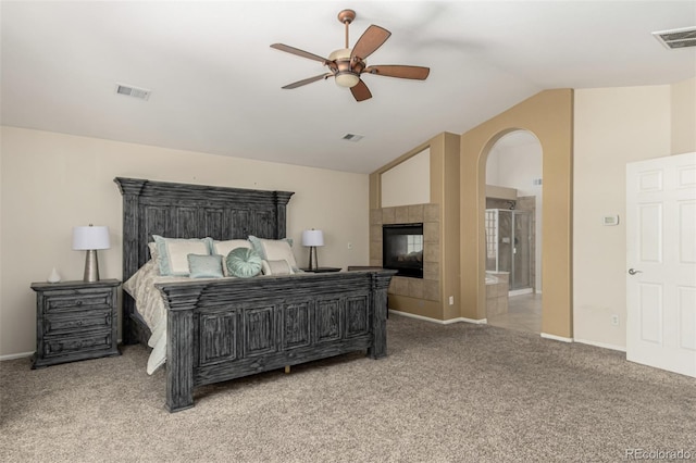7852 Solstice Way, Castle Rock, CO 80108 - bedroom with carpet, vaulted ceiling, a tile fireplace, arched walkways, and baseboards