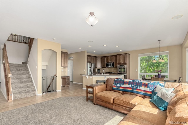 7852 Solstice Way, Castle Rock, CO 80108 - living area featuring baseboards, light wood-type flooring, recessed lighting, and stairway