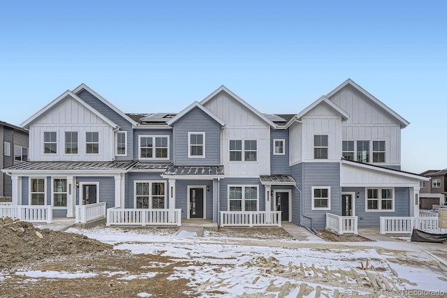 townhome / multi-family property featuring solar panels and a porch