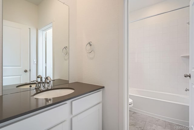 full bathroom with tile patterned floors, tiled shower / bath combo, toilet, and vanity