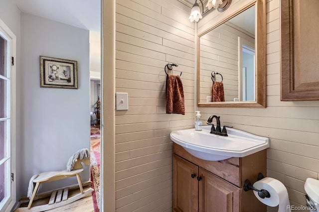8758 S Murphy Gulch Rd, Littleton, CO 80127 - bathroom featuring vanity, wood walls, and wood finished floors