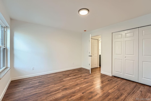 unfurnished bedroom featuring dark hardwood / wood-style floors and a closet