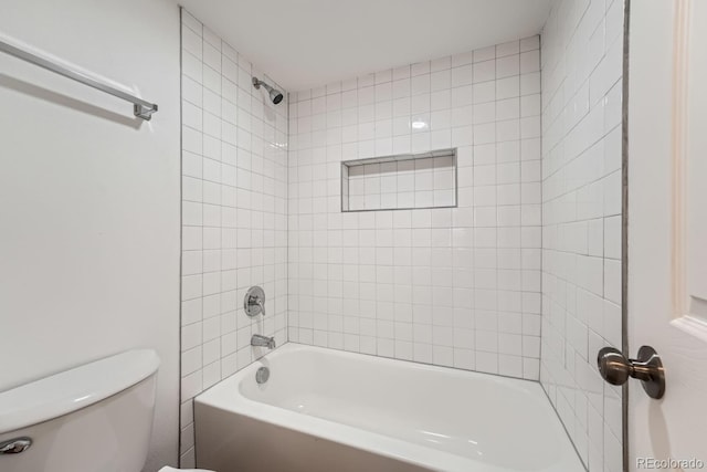 bathroom with tiled shower / bath combo and toilet