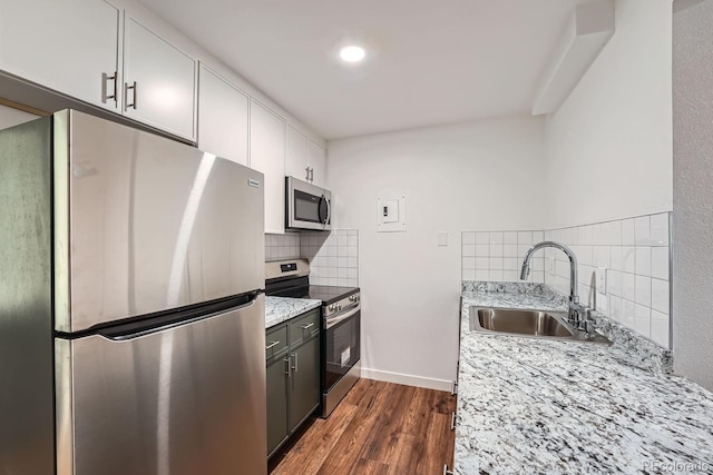 kitchen with white cabinetry, sink, dark wood-type flooring, light stone counters, and appliances with stainless steel finishes