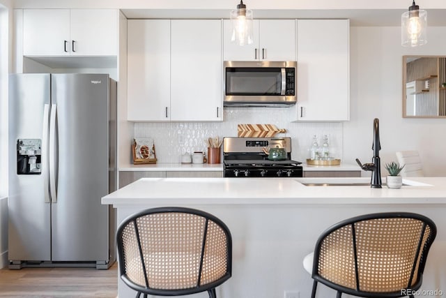 5227 N Eliot St, Denver, CO 80221 - kitchen featuring appliances with stainless steel finishes, light countertops, and a kitchen bar