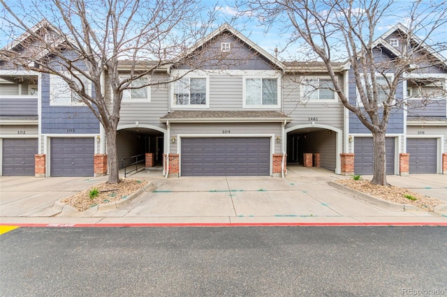 1461 S Danube Way Unit 104, Aurora, CO 80017 - view of front of property with brick siding, a garage, and driveway