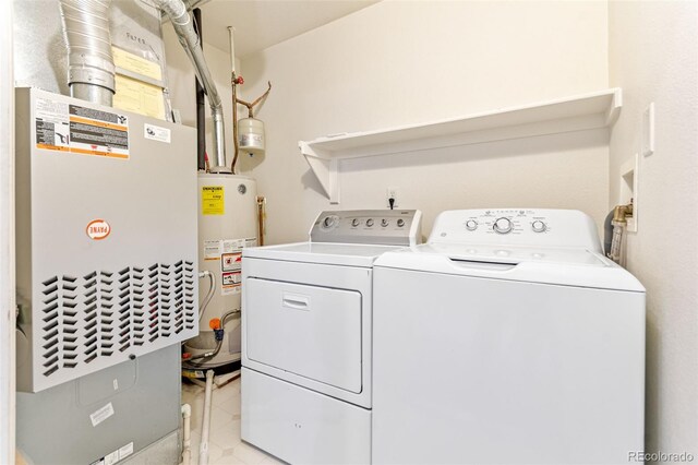 1461 S Danube Way Unit 104, Aurora, CO 80017 - laundry room with heating unit, gas water heater, laundry area, and washer and clothes dryer