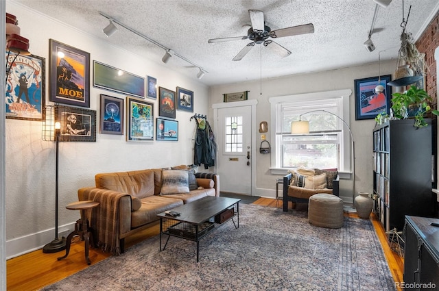 living room with ceiling fan, a textured ceiling, and hardwood / wood-style floors