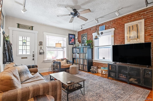 living room with ceiling fan, hardwood / wood-style flooring, and a textured ceiling