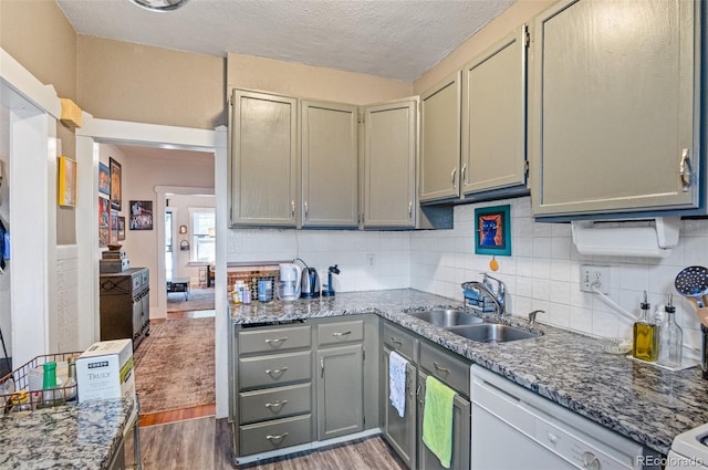 kitchen featuring dark stone countertops, sink, and dark wood-type flooring