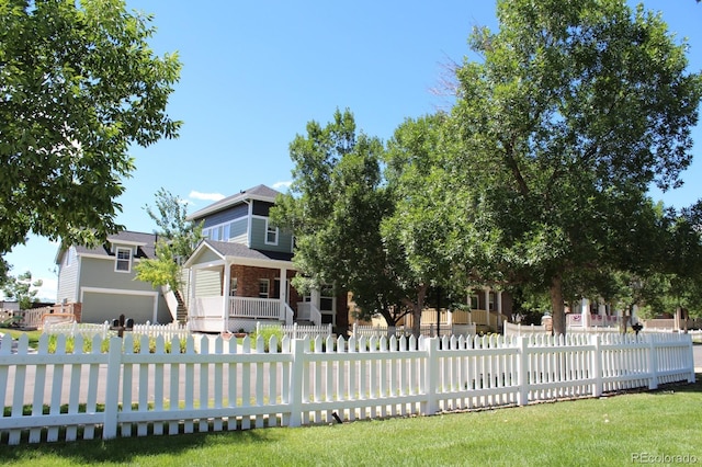 view of property hidden behind natural elements featuring covered porch