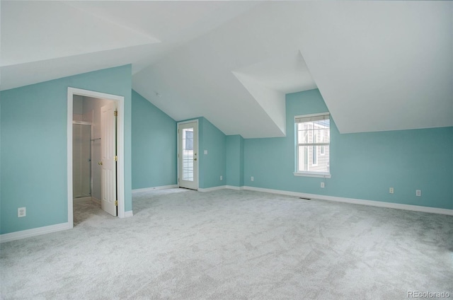 bonus room featuring light colored carpet and vaulted ceiling