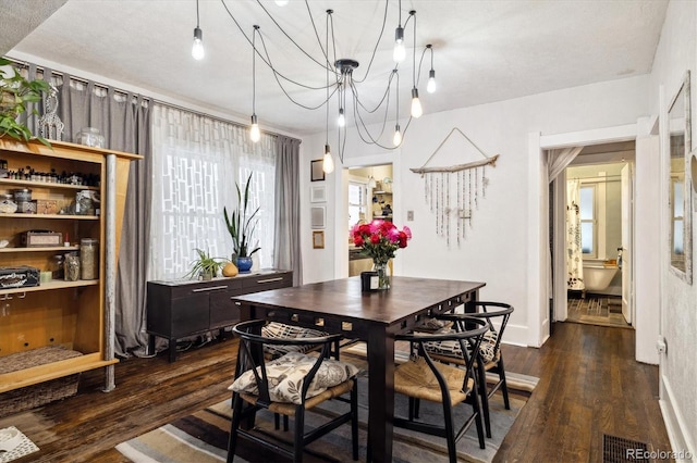 dining room featuring dark hardwood / wood-style floors and a chandelier