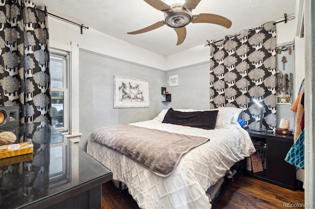 bedroom featuring a textured ceiling, ceiling fan, and dark wood-type flooring