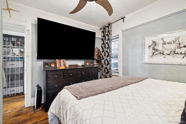 bedroom with a textured ceiling, dark hardwood / wood-style flooring, and ceiling fan