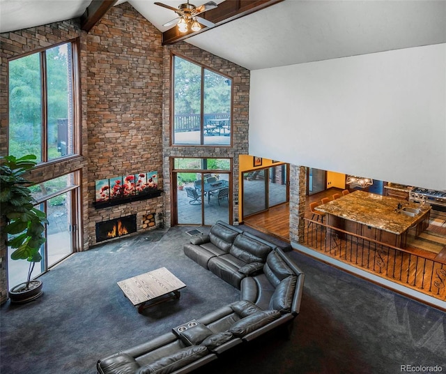 exercise area with high vaulted ceiling, ceiling fan, carpet floors, and a stone fireplace