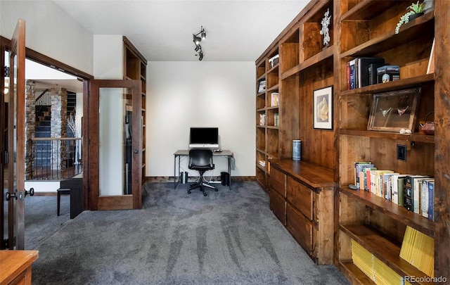 home office with track lighting, french doors, and dark colored carpet