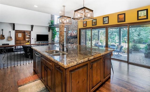 kitchen featuring an inviting chandelier, dark stone countertops, a sink, and wood finished floors