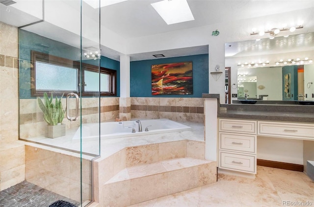 bathroom featuring a shower stall, tile patterned flooring, a garden tub, vanity, and a skylight