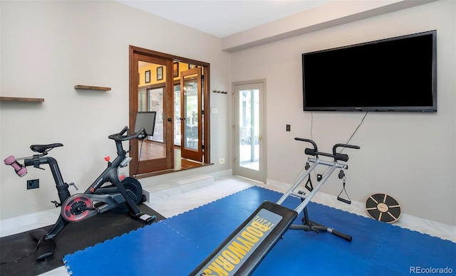 workout room featuring baseboards and french doors