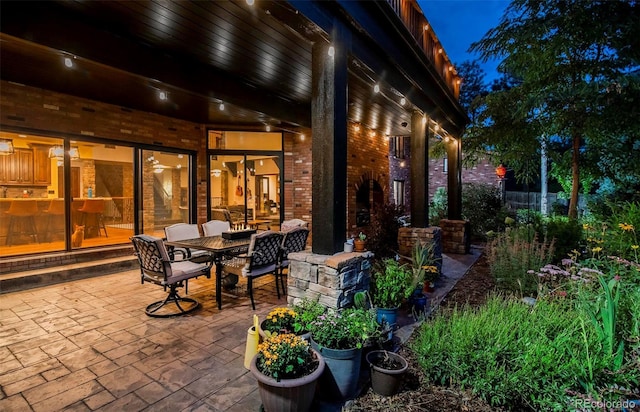 patio at night featuring outdoor dining area