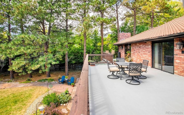 view of patio / terrace with a deck, outdoor dining space, and fence