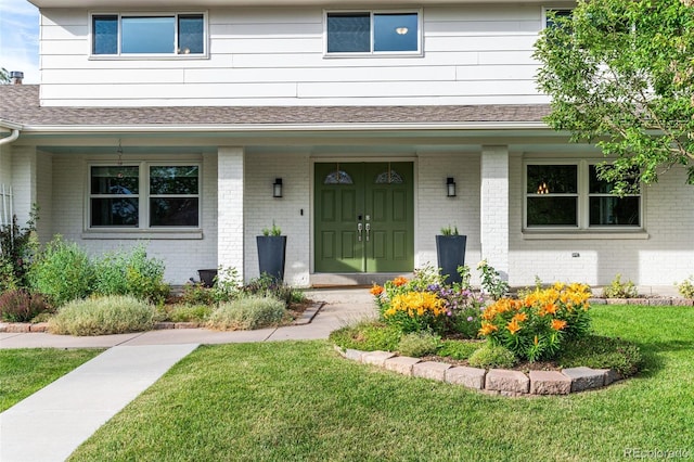 view of exterior entry with a lawn