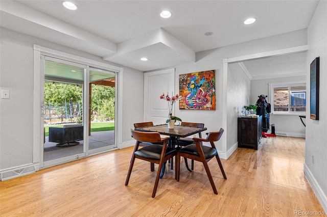 dining space featuring crown molding and light wood-type flooring