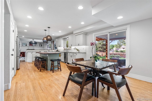 dining area featuring sink, plenty of natural light, and light hardwood / wood-style floors