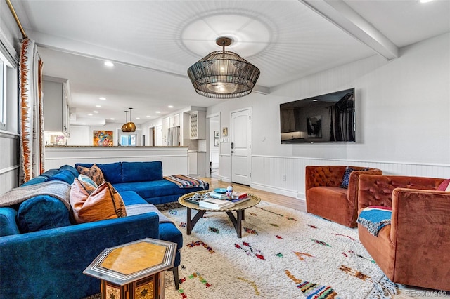 living room with beamed ceiling and light wood-type flooring