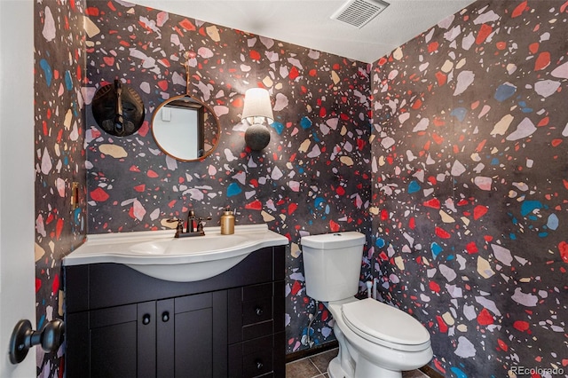 bathroom featuring tile patterned flooring, vanity, and toilet