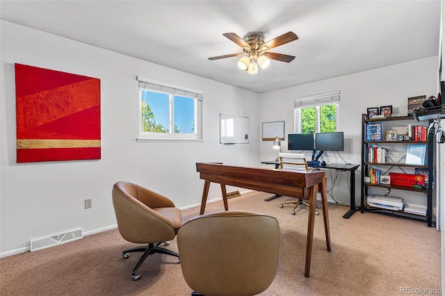 carpeted office space featuring ceiling fan