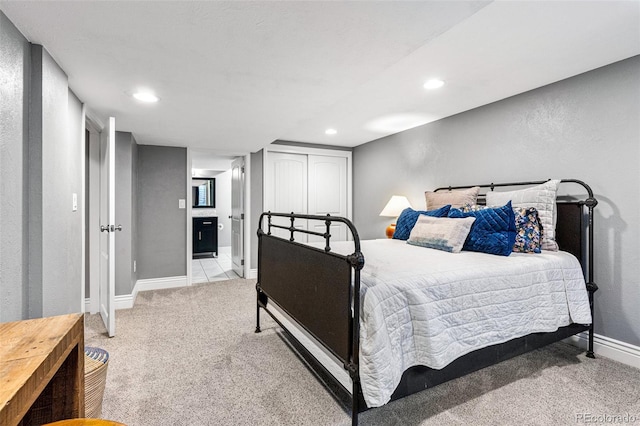 bedroom with light colored carpet and ensuite bath