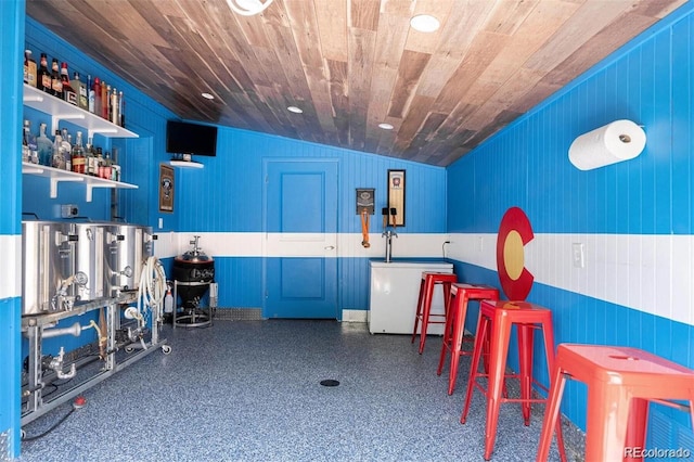 bar featuring blue cabinetry, lofted ceiling, wood ceiling, and refrigerator