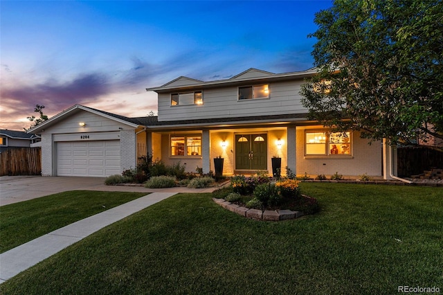 view of front of house with a garage and a lawn