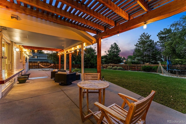 patio terrace at dusk with a pergola, a trampoline, and a lawn