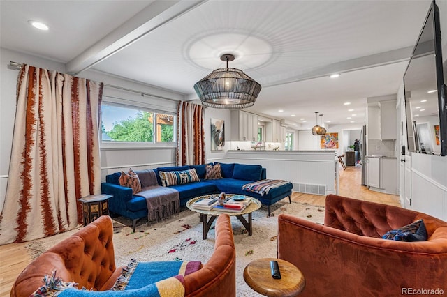 living room featuring light hardwood / wood-style floors and beamed ceiling