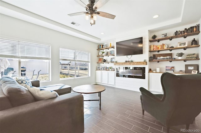 living room featuring a ceiling fan, visible vents, wood tiled floor, recessed lighting, and a raised ceiling