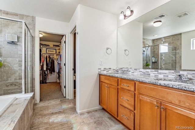 bathroom with a sink, visible vents, a stall shower, and double vanity