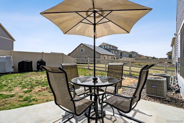 view of patio / terrace with outdoor dining area, central AC unit, and a fenced backyard