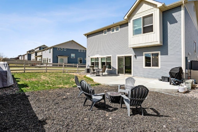 rear view of property featuring a patio, fence, and board and batten siding