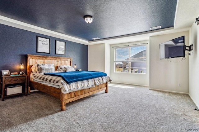 bedroom featuring visible vents, baseboards, a tray ceiling, carpet floors, and a textured ceiling