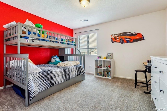 carpeted bedroom featuring visible vents, a textured ceiling, and baseboards