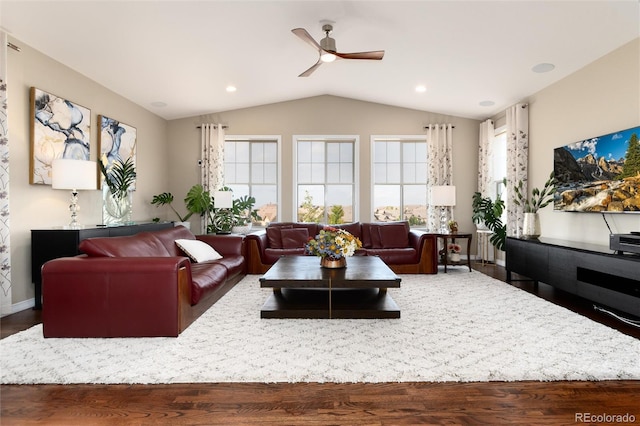 living room with dark wood-type flooring, ceiling fan, vaulted ceiling, and a healthy amount of sunlight